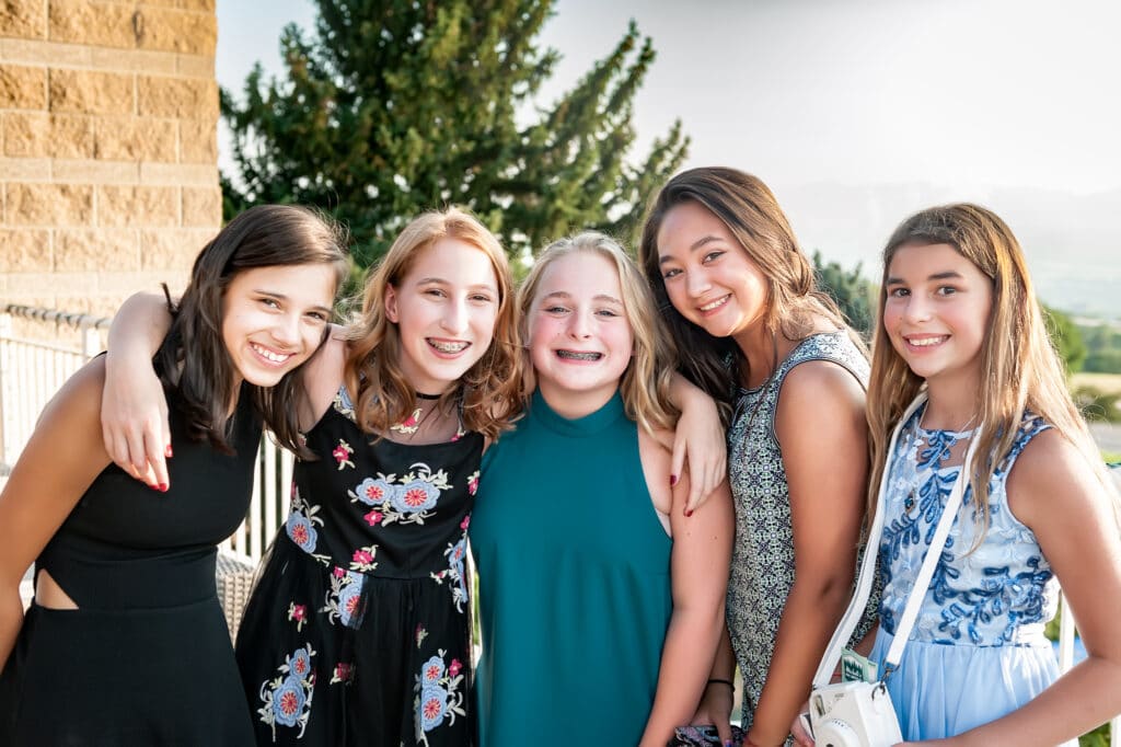 Best friends at a young woman's bat mitzvah outdoor celebration pose for a group photo.
