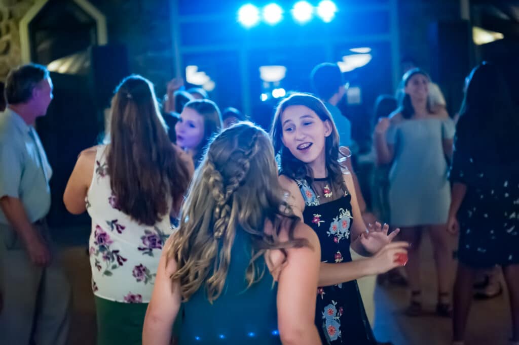 Colored lights from the DJ create a fun dance party for this bat mitzvah party.