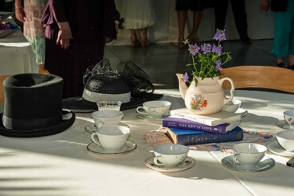 Teapots, books and hats add style to the table of this tea-party themed wedding.