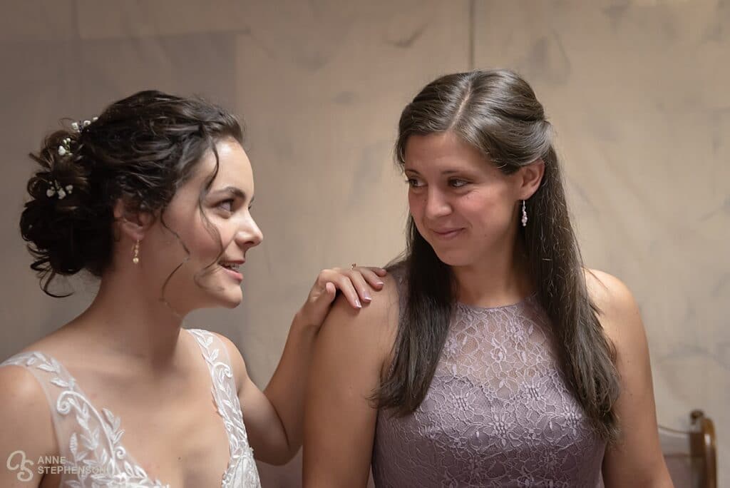 The bride looks to her friend to steady her nerves before the wedding.