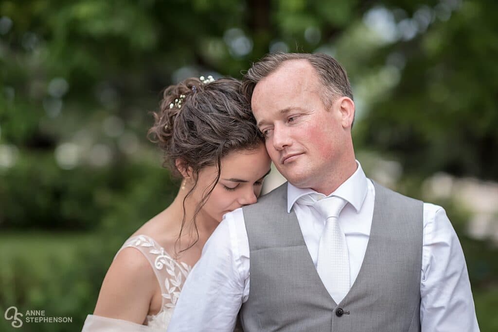 The bride rests her head on the groom's shoulder, sharing a final quiet moment at the end of the day.