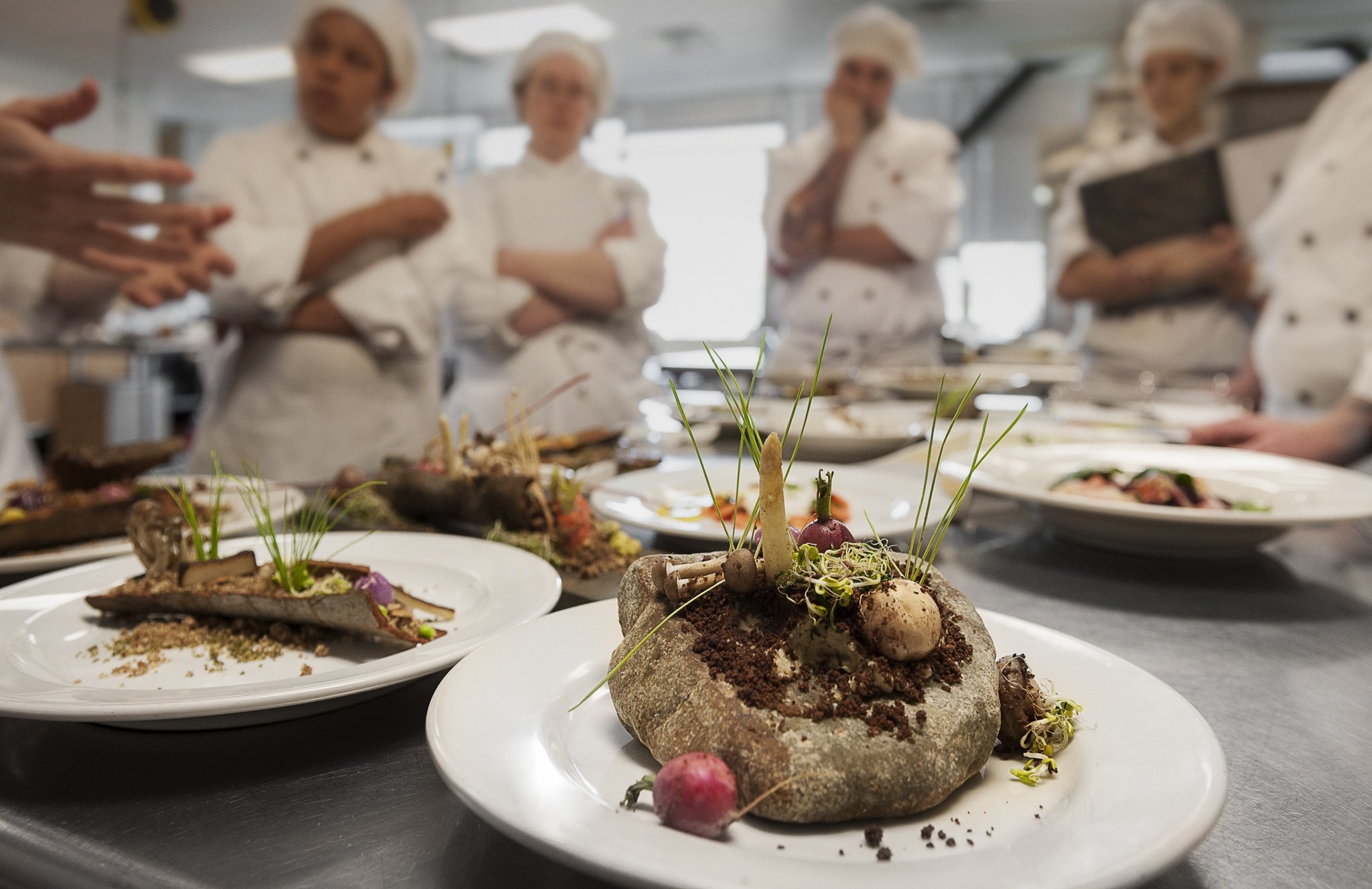 Culinary students receive feedback from their Chef instructor.