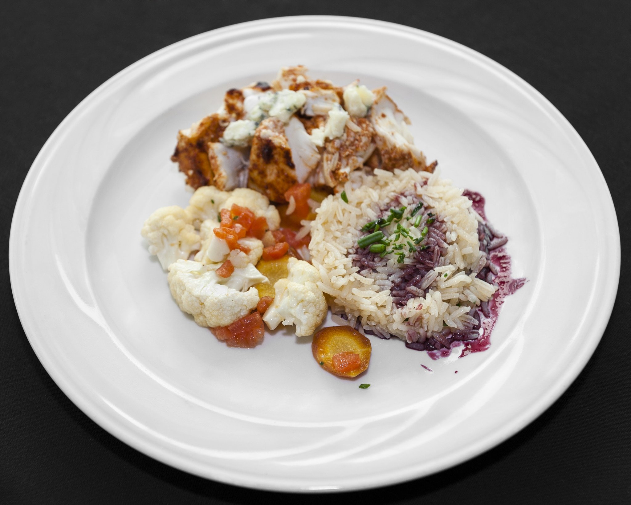 Colorful plate of halibut, rice, cauliflower.