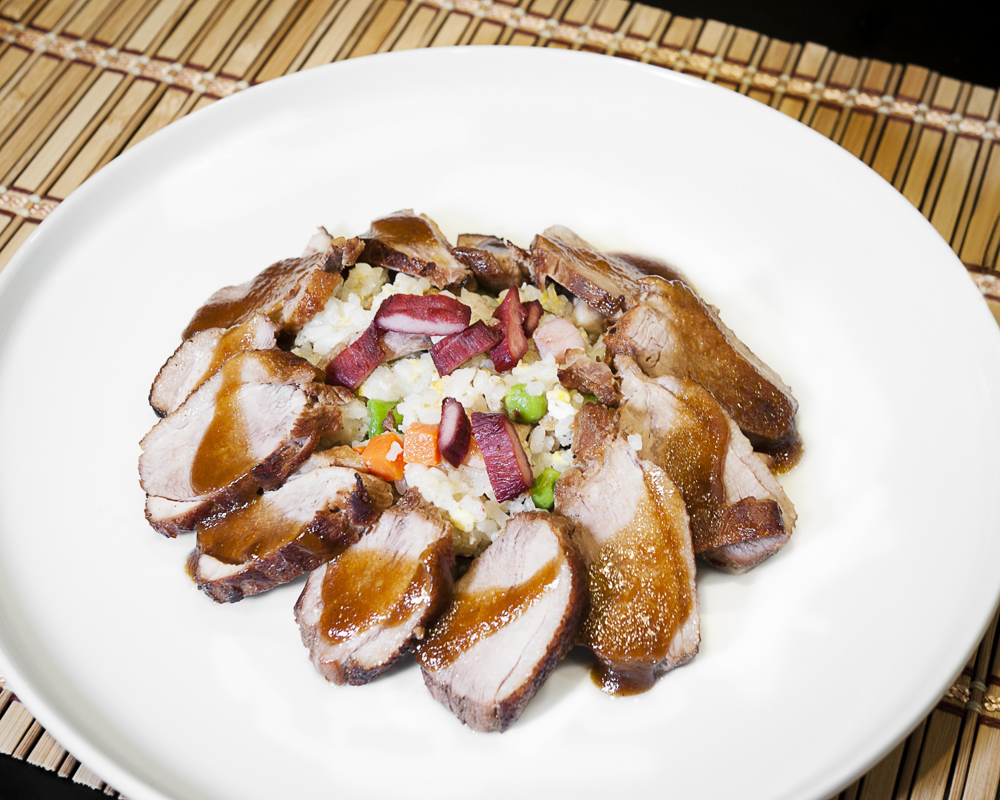 Plated pork dish with rice and sauce from the Culinary Trip to Asia Class.