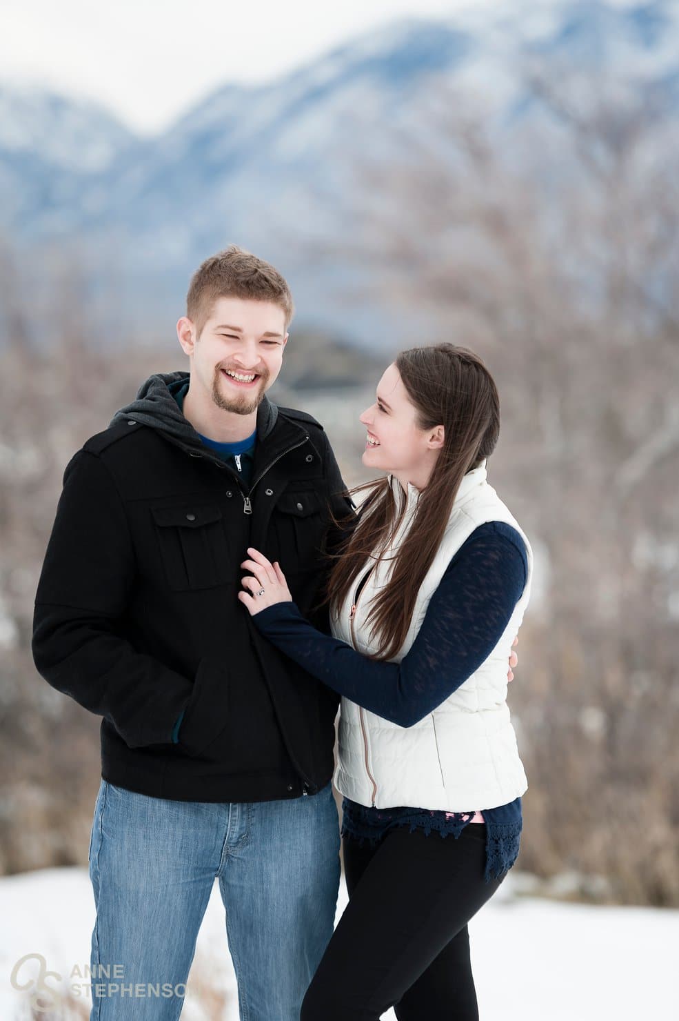 An engaged couple link arms and stay warm during a winter photo session.