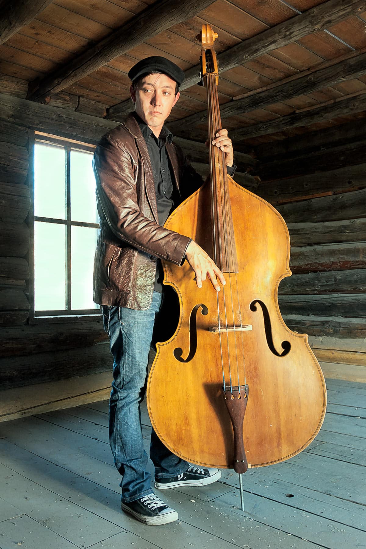 A bass player in a historic cabin.