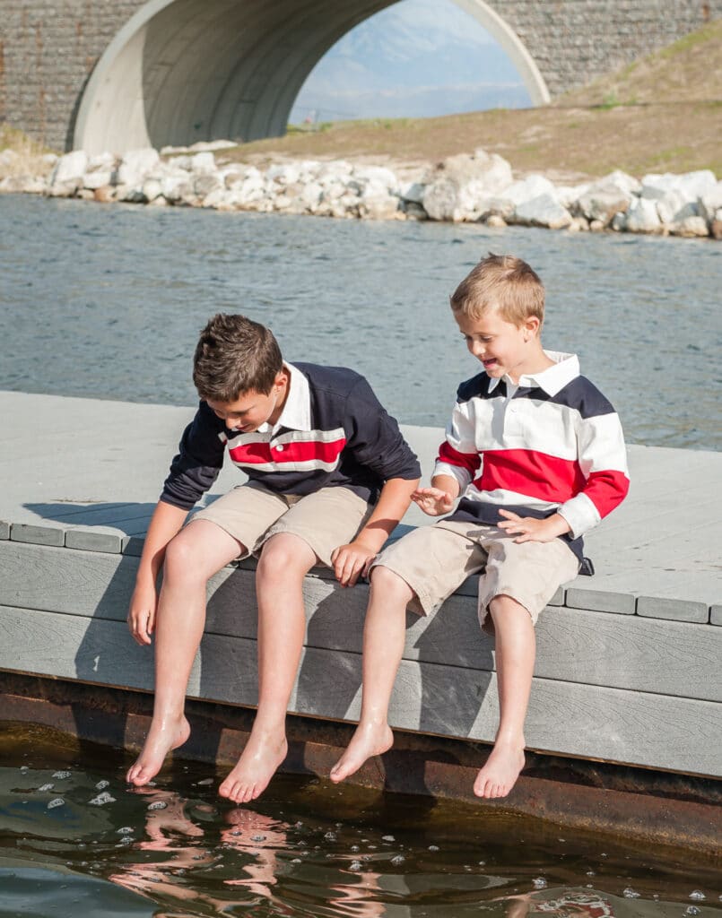 Two brothers with bare feet on a pier