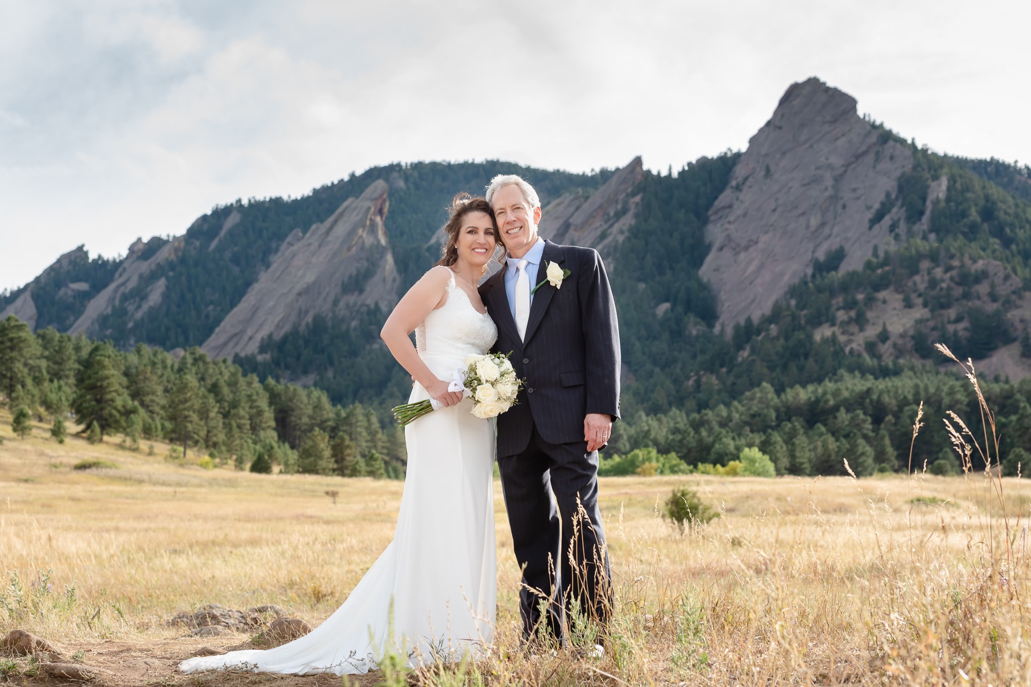 Older wedding couple standing in front of the FlatIrons after their wedding at Chautauqua Park, Boulder.