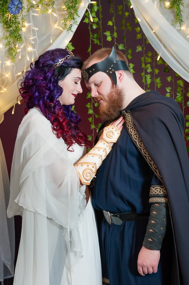 Bride and groom in D&D costumes share a tender moment.