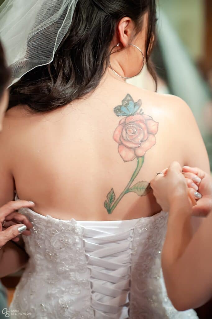 Close up of the rose tattoo and the bridesmaids icing down her back on this hot summer wedding day.