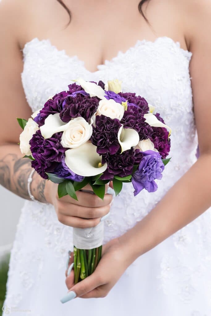 Close up of the bride's bouquet with stunning white lilies and various shades of purple flowers.