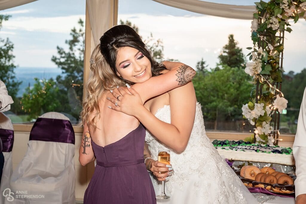 The maid of honor hugs the bride during the toasts.