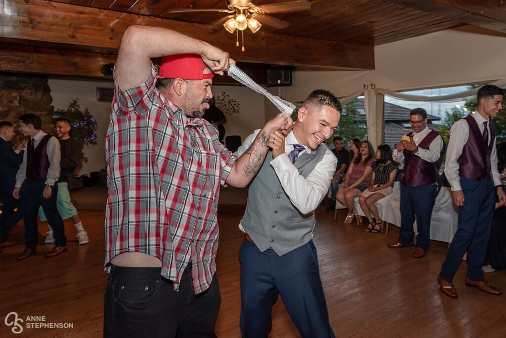 After catching the garter, the man uses it as a sling shot and messes with the groom.