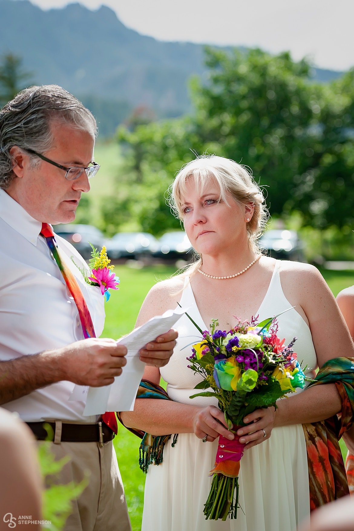 The bride has tears in her eyes as she gazes lovingly at her husband-to-be during their non-conventional tie-dye wedding.