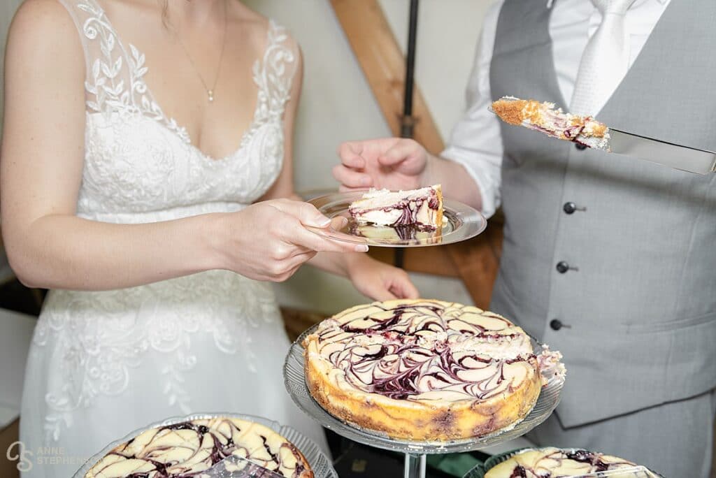 The bride and groom cut the wedding cheesecake.