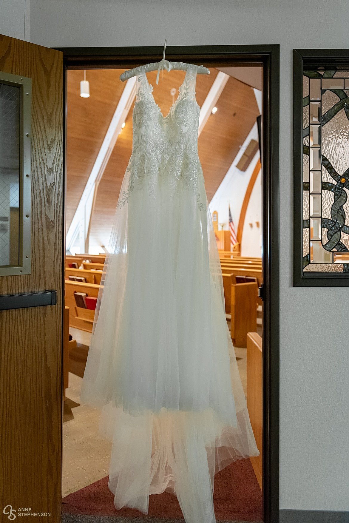 The bride's dress framed by the doorway into the church.