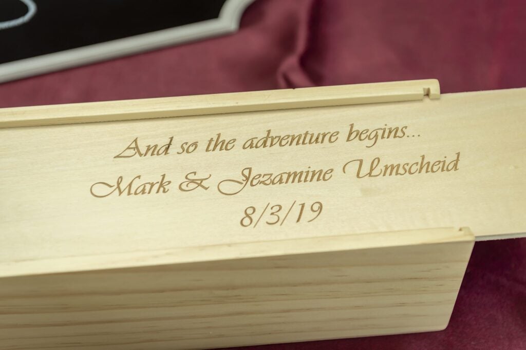 The lid of a Jenga game etched with the names and wedding date of the bride and groom.