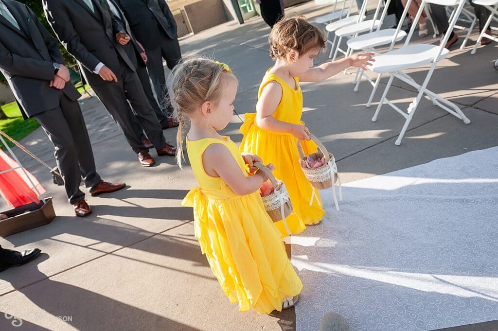 The flower girls suddenly remember to cast their petals at the front of the aisle and start back down to complete the job.