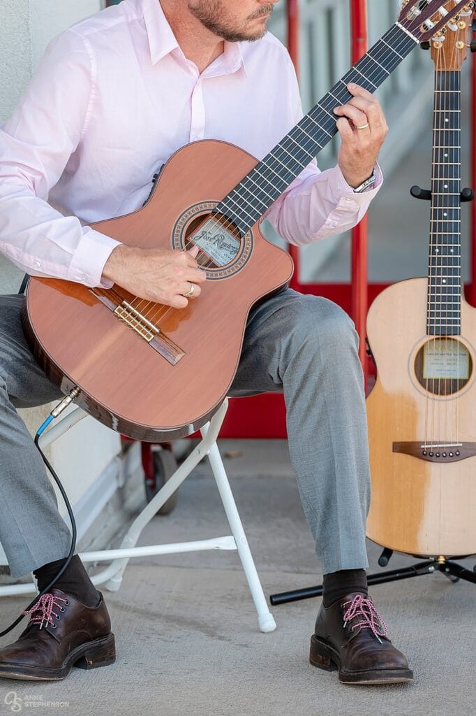 Close up of musician Michael Lancaster playing guitar at a wedding.