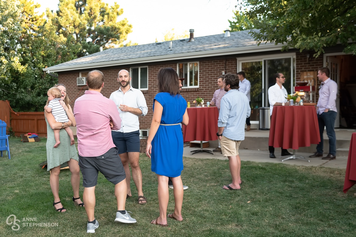 Guests gather in a friend's backyard to celebrate the recent wedding of their friends.