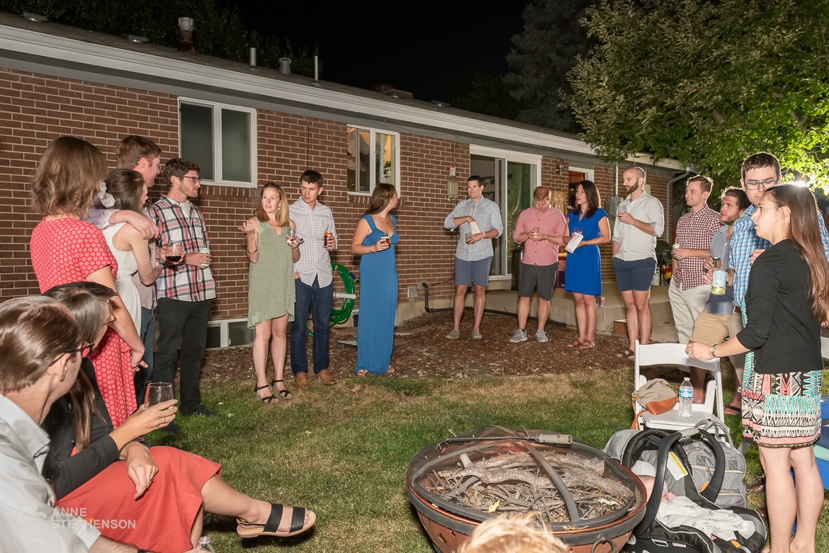 Wide view of guests at a backyard party toasting their recently married friends.