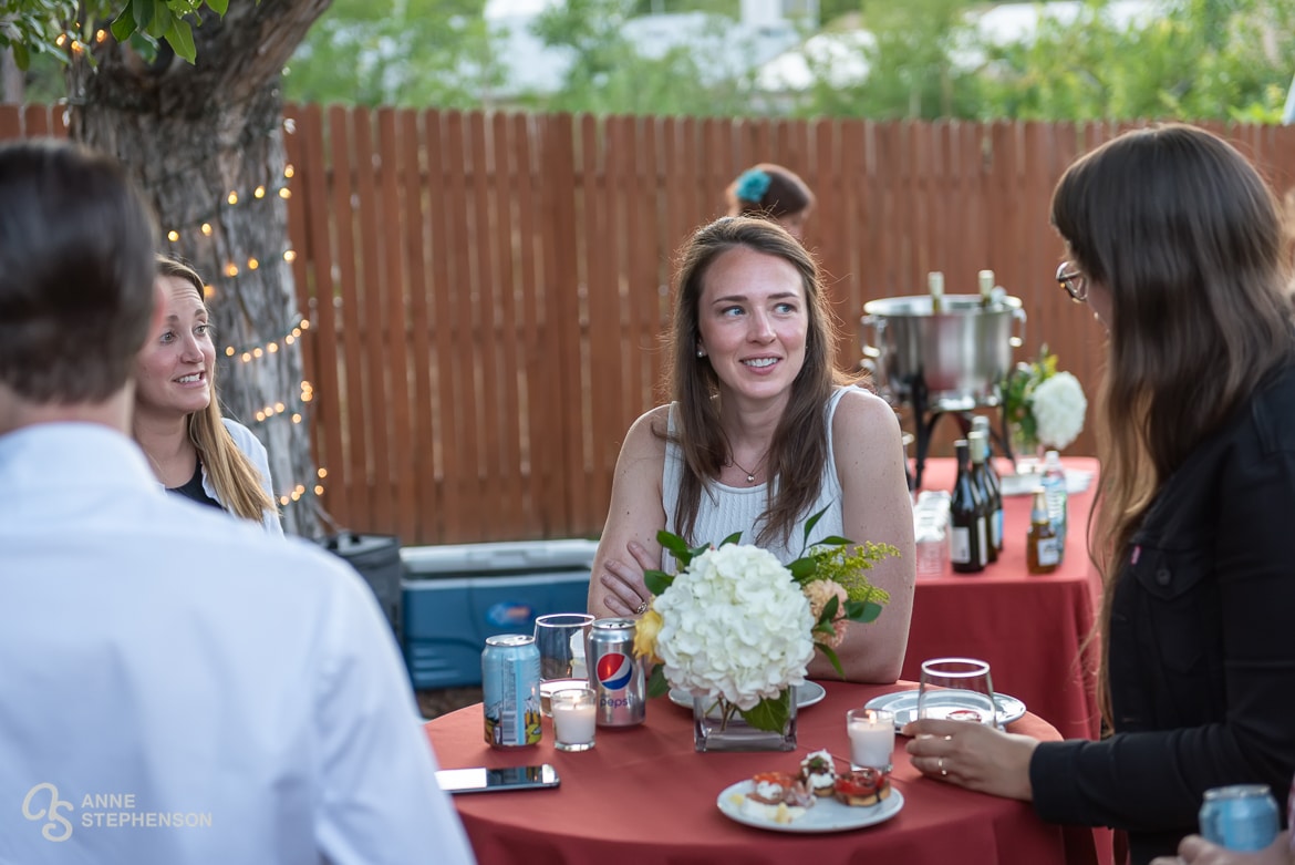 The bride engages in conversation with her Boulder friends gathered to celebrate her recent wedding in Chicago.