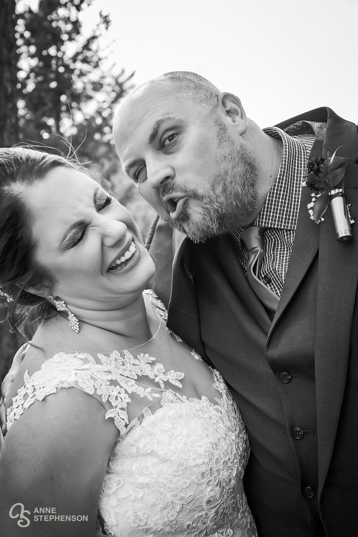 The groom makes a silly face for the bride before giving her a kiss.