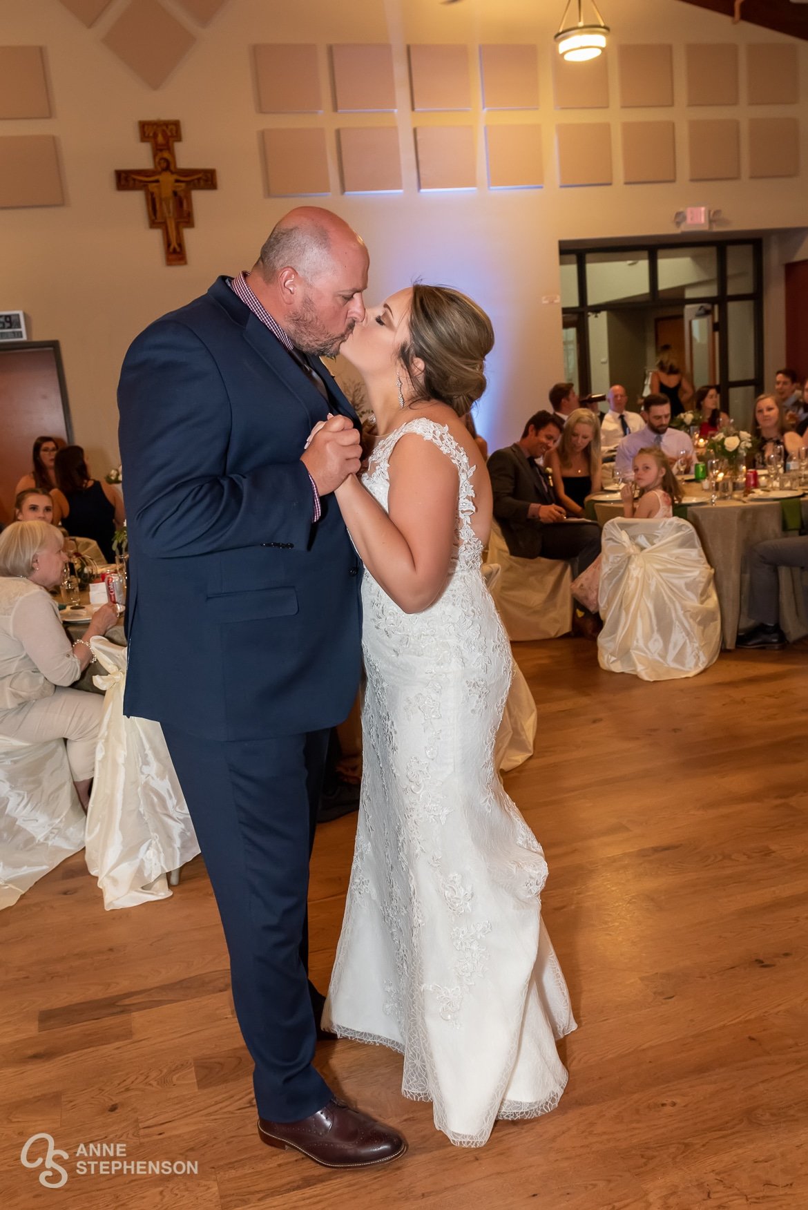 A bride and groom kiss at the end of their first dance celebration.