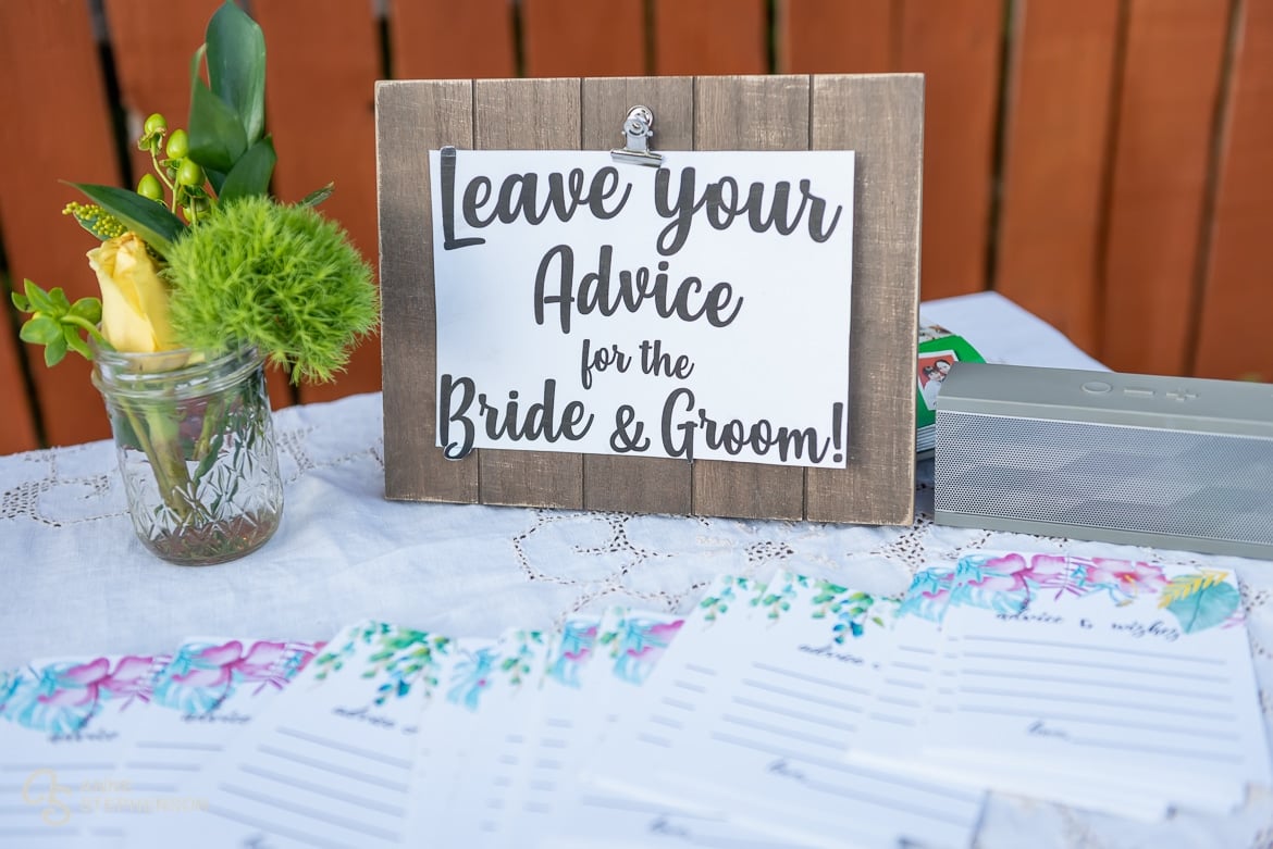 A table with a sign asking guests to leave advice for the bride and groom on slips of paper.