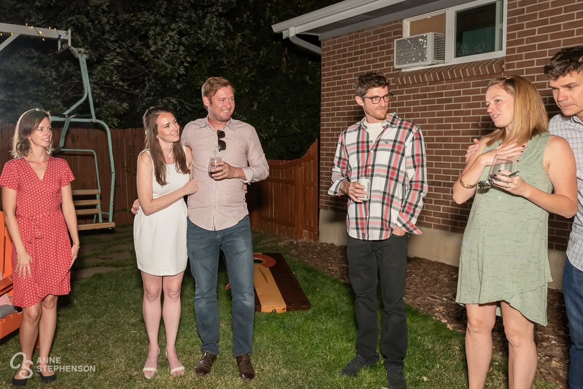 Hostess says a few words to her recently married friends as the guests look on.