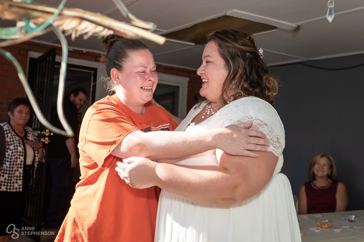 A friend from school days makes a surprise entrance and gives the bride a hug.