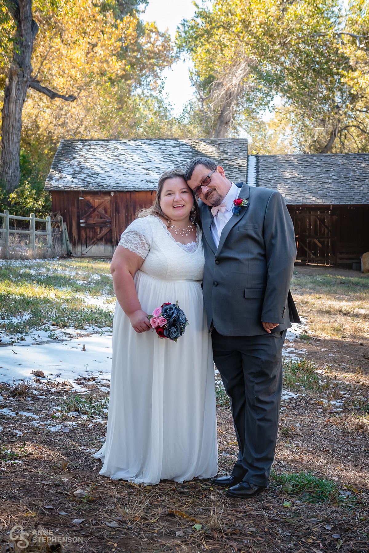 The bride and groom in front of Boyko Barn and the snowy landscape.