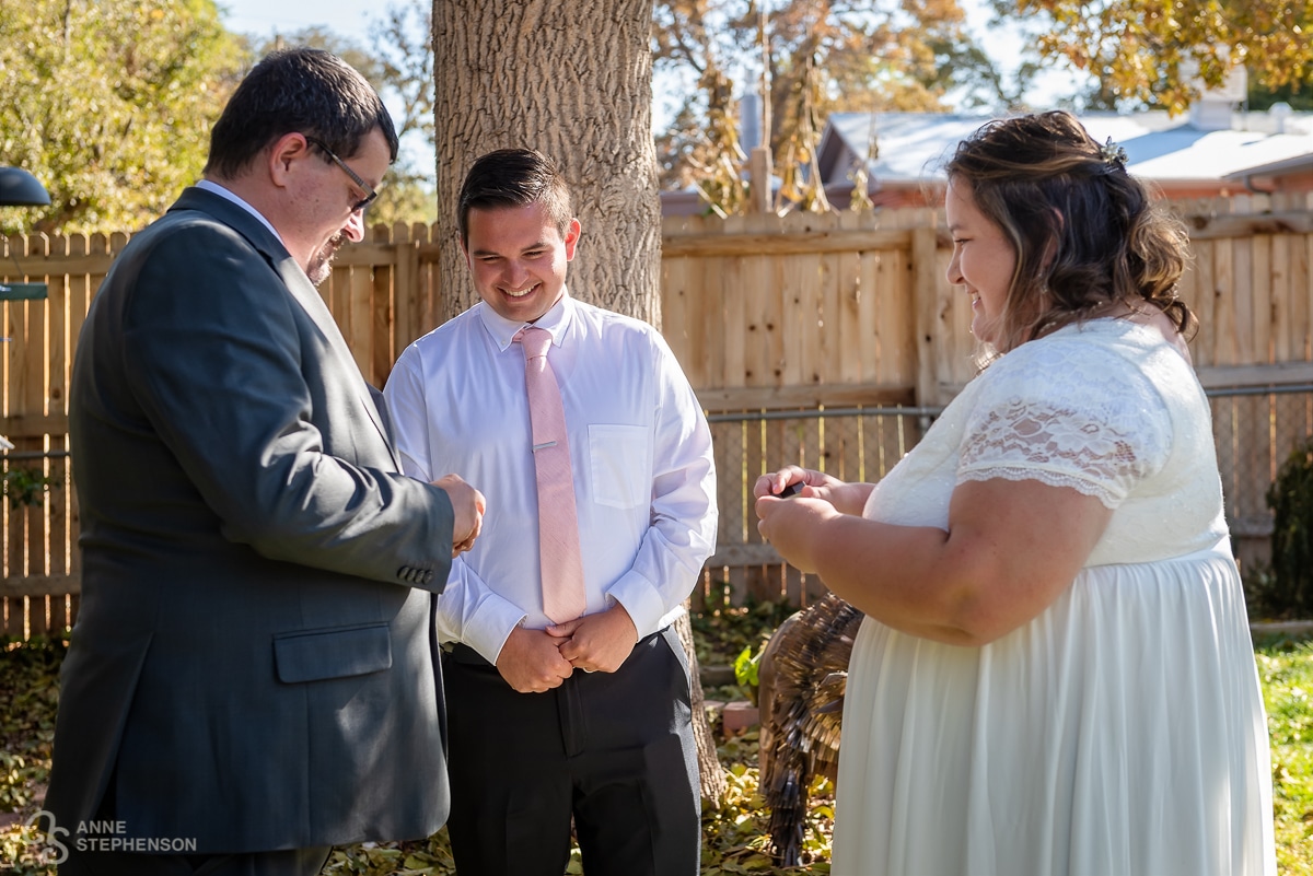 The bride and groom exchange rings during the ceremony officiated by the brother of the bride.