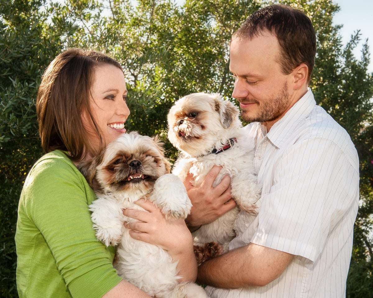 A man and woman hold their fur babies during a portrait session.