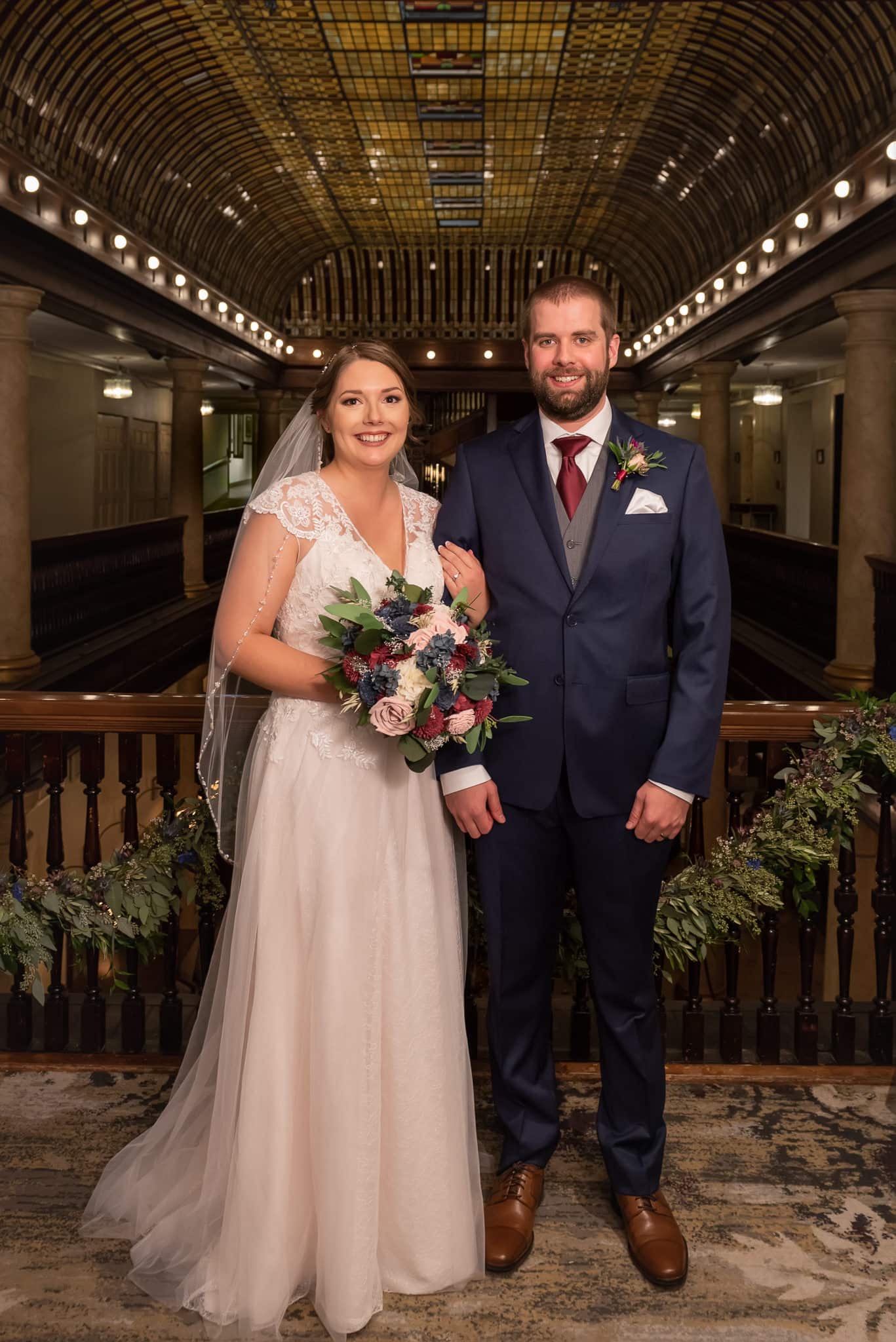 A bride and groom stand on the balcony of the historic Hotel Boulderado where they just married.