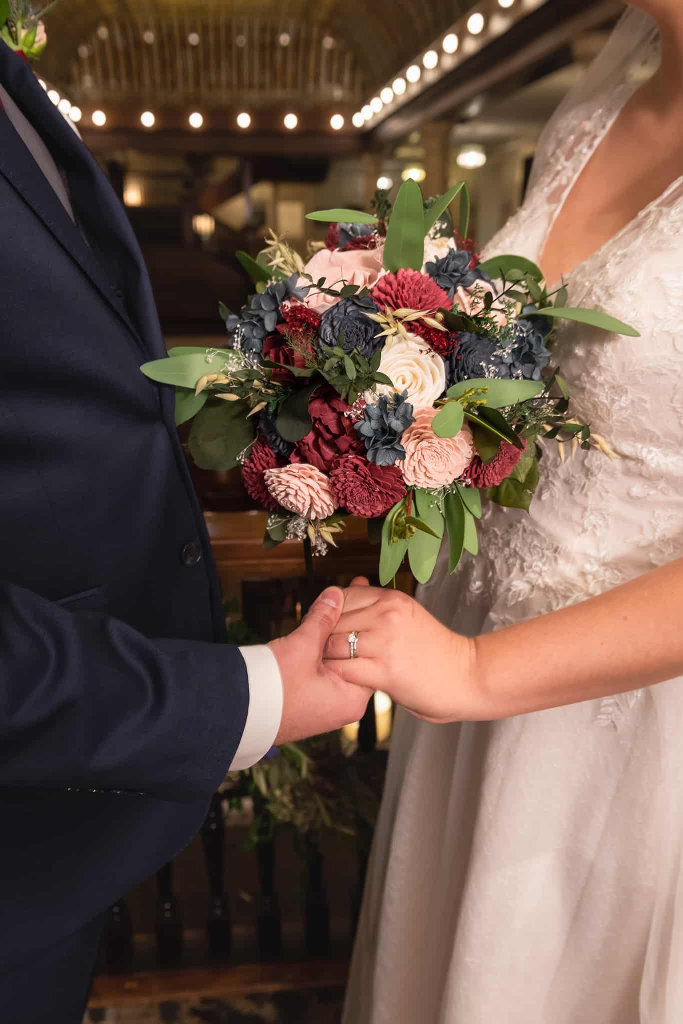 Close up of a bridal bouquet in varying shades of navy, pink, and deep red.