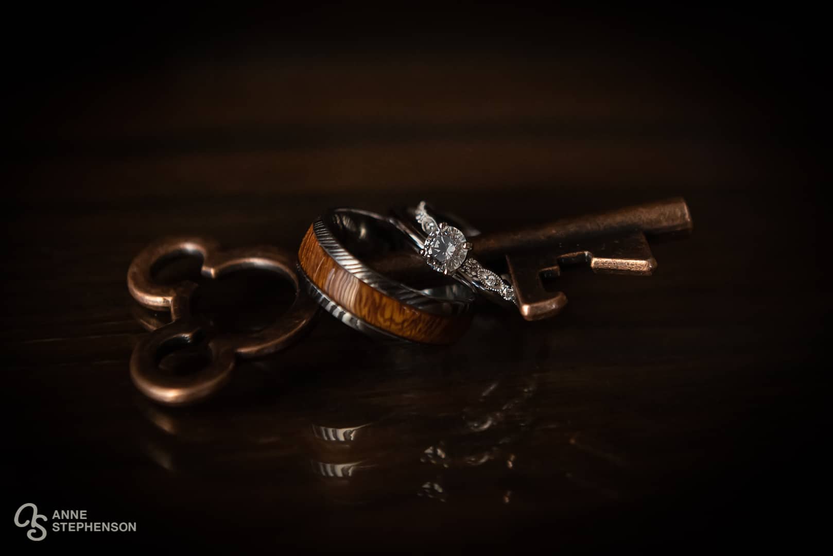 A men's and women's wedding and engagement rings are placed on a Mickey Mouse Bottle Opener.