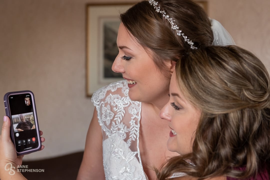 The bride and her sister talk on a video call with their grandparents who were unable to attend the wedding.