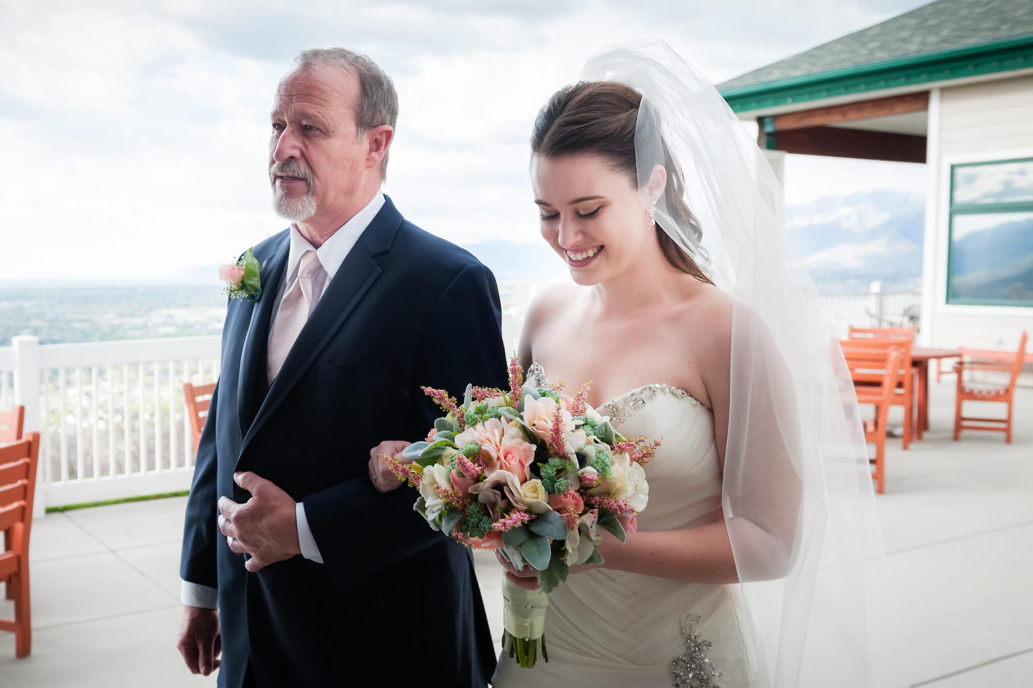 A dad prepares to walk his daughter down the wedding aisle at an outdoor wedding.