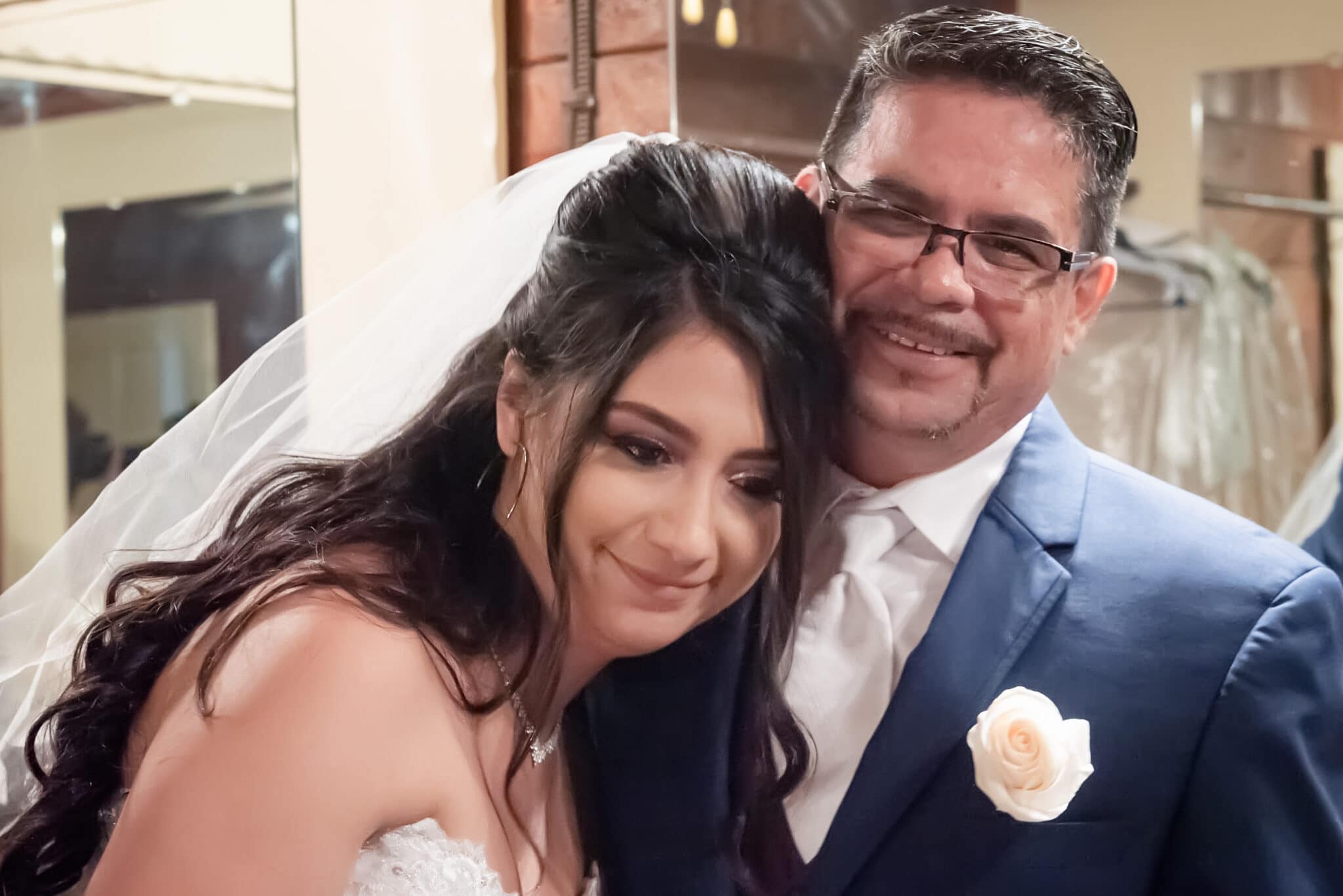 A father and daughter hug after a personal father-daughter first look.