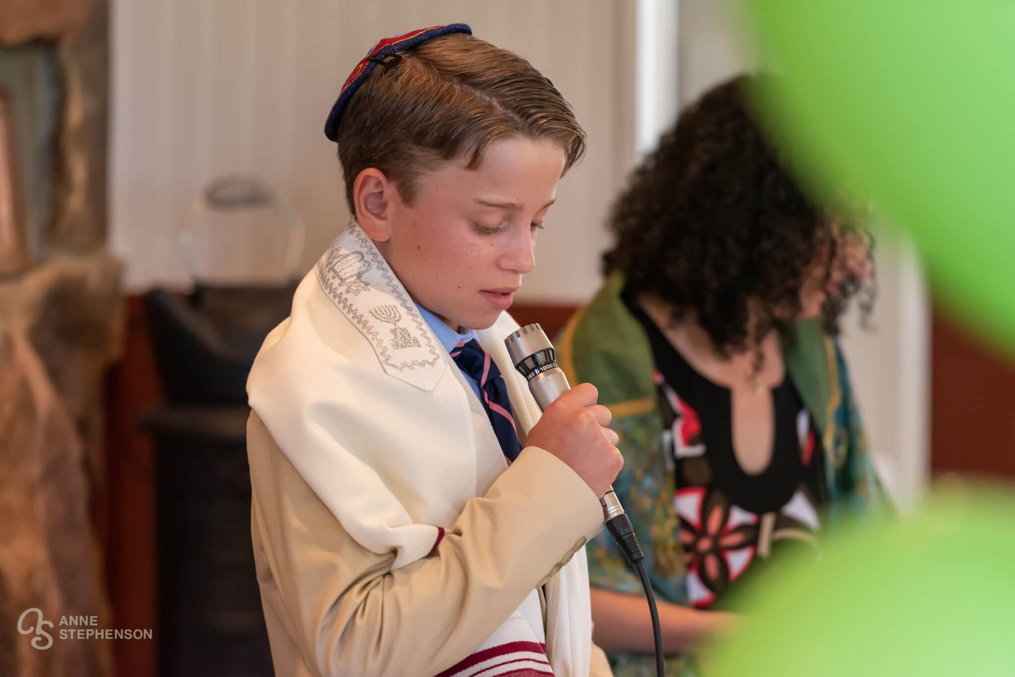 A young man with a microphone at a bar mitzvah.