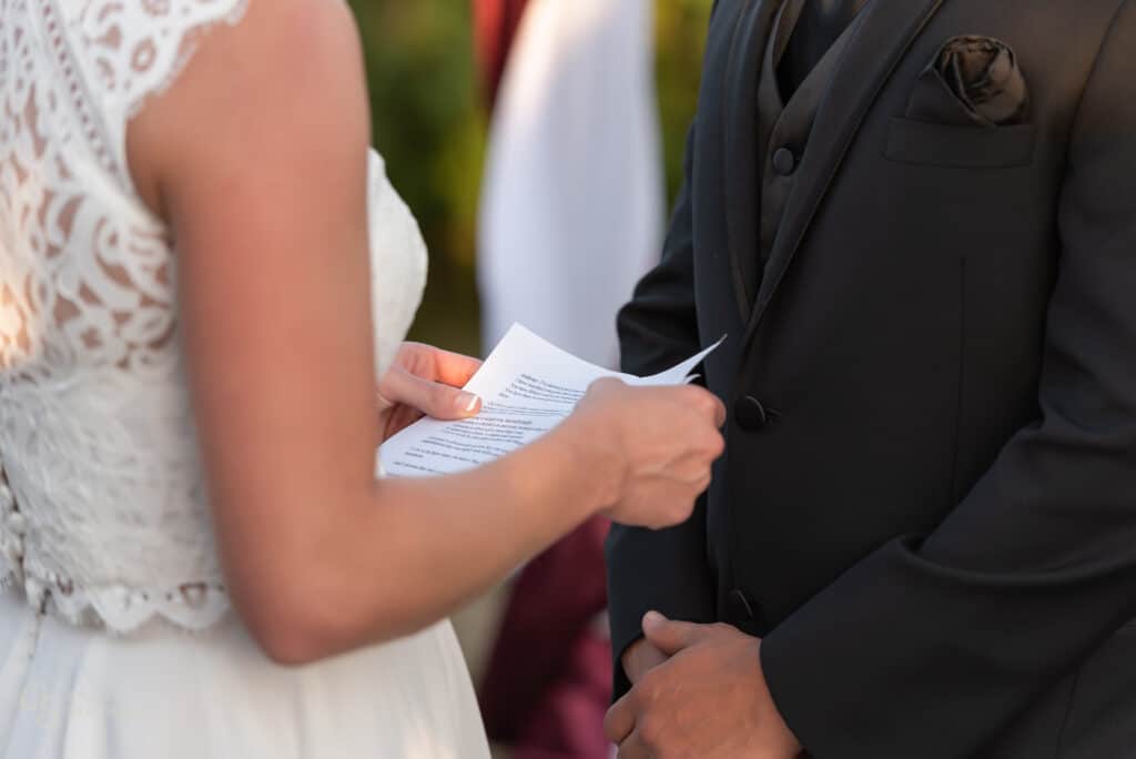 Close up of the bride's hands holding a sheet of paper with her personally written vows.