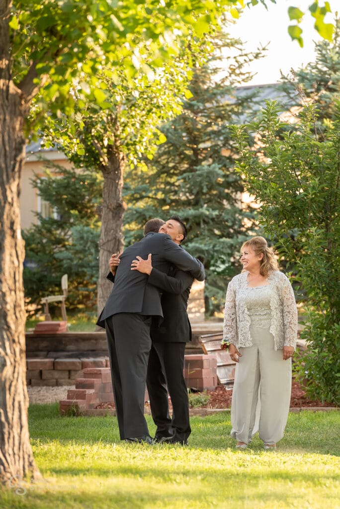 The father of the groom gives his son a bear hug before the ceremony.