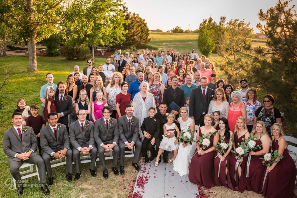 Large group photo taken from a ladder showing everyone in attendance at this prairie wedding at sunset in Brighton.