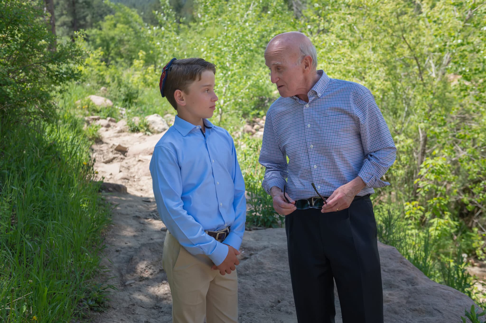 Poppa shares wisdom with his grandson during a nature hike.