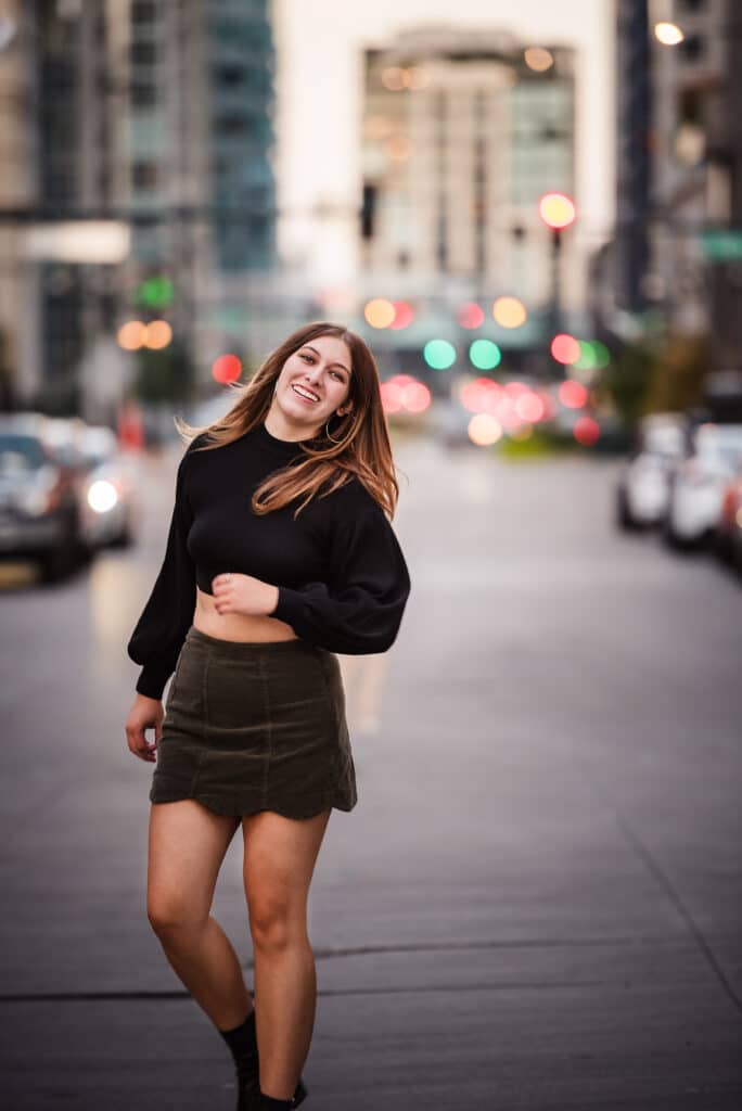 A young woman with street lights behind her in the Denver theater district.