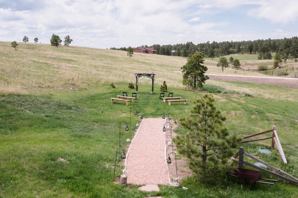 A bird's-eye view of the wedding aisle and arch at 1C Barn, a rustic venue outside of Colorado springs.