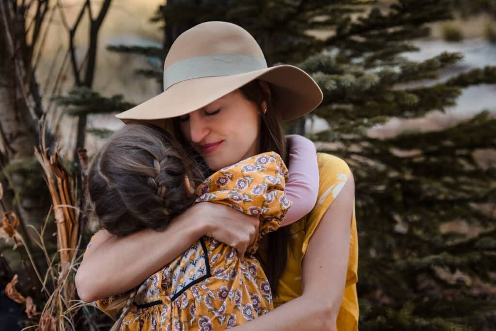 A mother holds her daughter closely at a family portrait session.