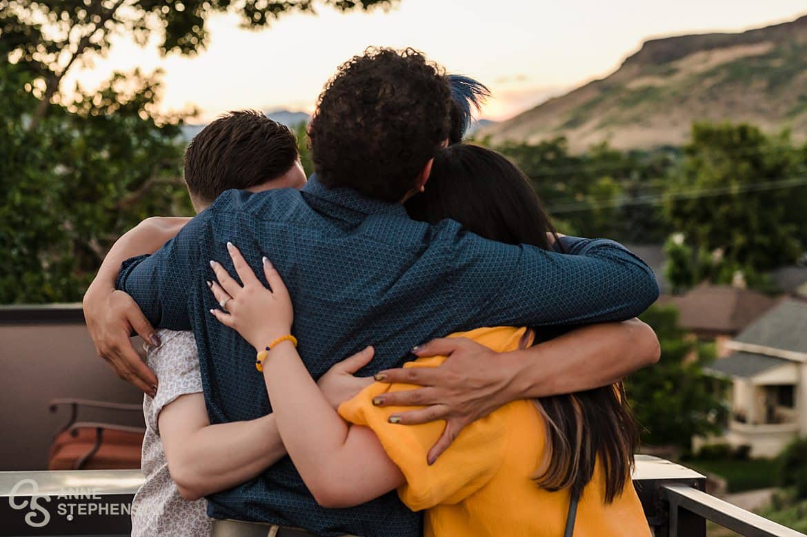Close up of a hug circle of a newly engaged couple and a couple of friends.