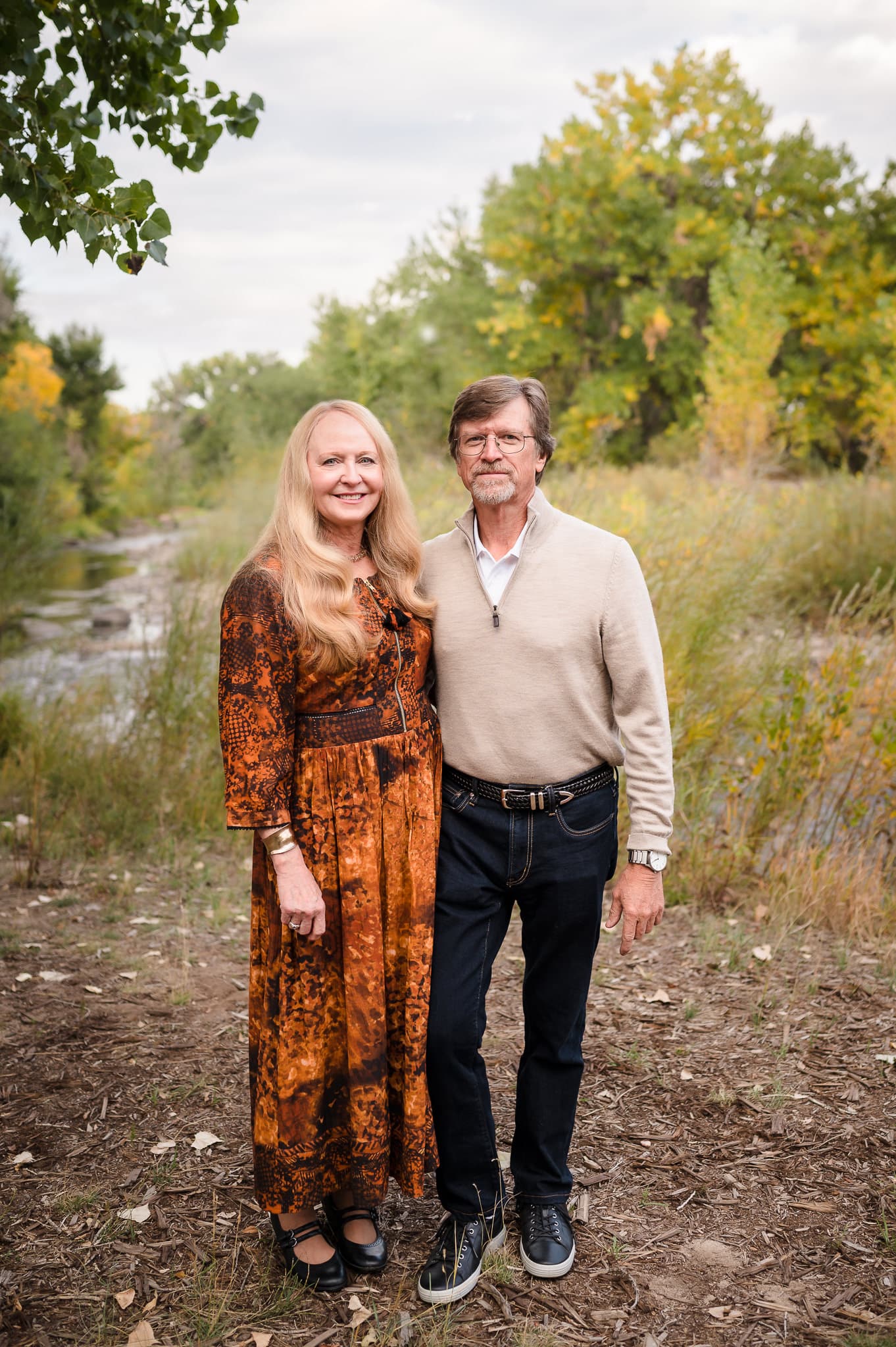 An autumn portrait with changing leaves in the background of a man and woman celebrating their 40th wedding anniversary.